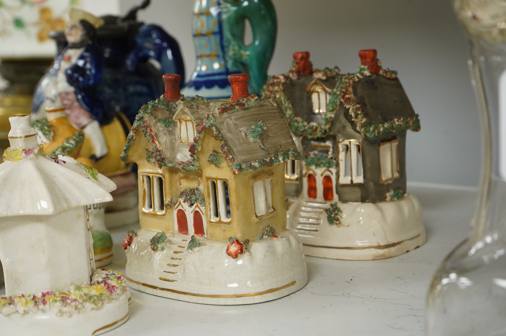 A group of various Victorian Staffordshire pottery models of cottages and various figure moulded vessels together with an Italian maiolica ewer, tallest 25cm